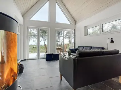 a living room with a couch and a fireplace at Holiday Home Angelita - 80m to the fjord by Interhome in Thyholm