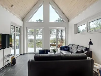 a living room with a couch and a tv at Holiday Home Angelita - 80m to the fjord by Interhome in Thyholm