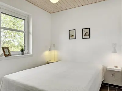 a white bedroom with a bed and a window at Holiday Home Angelita - 80m to the fjord by Interhome in Thyholm