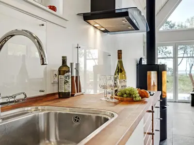 a kitchen with a sink and some wine bottles at Holiday Home Angelita - 80m to the fjord by Interhome in Thyholm