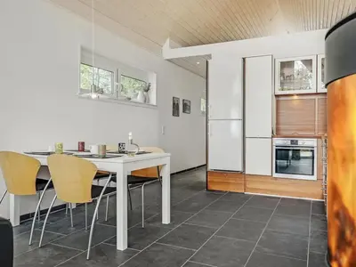 a kitchen with a table and chairs and a refrigerator at Holiday Home Angelita - 80m to the fjord by Interhome in Thyholm
