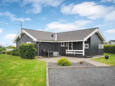 a gray house with a table in a yard at Holiday Home Brynjolf - 350m to the fjord by Interhome in Vinderup