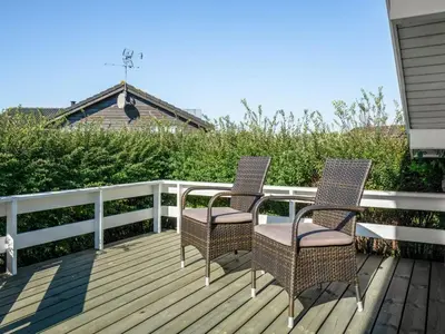 two chairs sitting on a wooden deck at Holiday Home Brynjolf - 350m to the fjord by Interhome in Vinderup