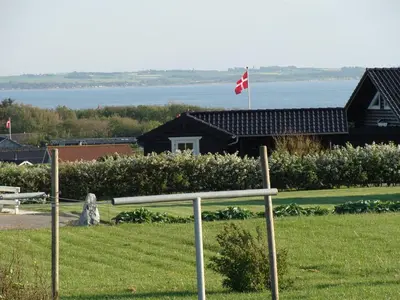 a house with a canadian flag in the grass at Holiday Home Brynjolf - 350m to the fjord by Interhome in Vinderup