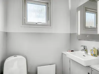 a white bathroom with a toilet and a sink at Holiday Home Milan - 250m to the fjord by Interhome in Thyholm