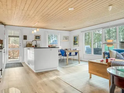 a kitchen and living room with white cabinets and a table at Holiday Home Milan - 250m to the fjord by Interhome in Thyholm