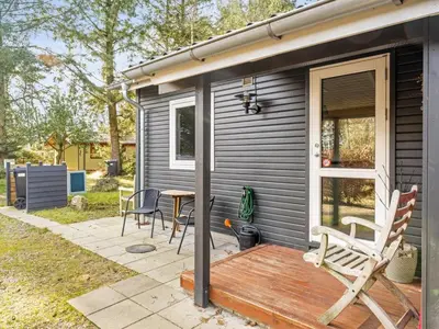 a house with a deck with chairs and a table at Holiday Home Milan - 250m to the fjord by Interhome in Thyholm