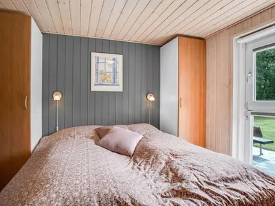 a bedroom with a bed with two lamps and a window at Holiday Home Yorrit - 500m to the fjord by Interhome in Højslev