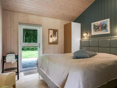 a bedroom with a large bed and a window at Holiday Home Yorrit - 500m to the fjord by Interhome in Højslev