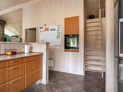a kitchen with wooden cabinets and a counter top at Holiday Home Yorrit - 500m to the fjord by Interhome in Højslev