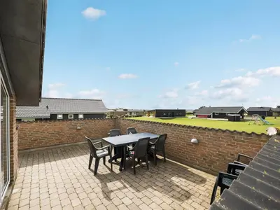 a patio with a table and chairs and a brick wall at Holiday Home Alboldus - 250m to the fjord by Interhome in Vinderup