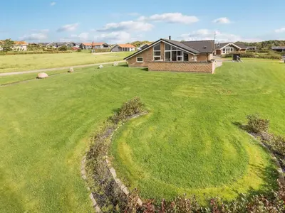 a large green yard with a house in the background at Holiday Home Alboldus - 250m to the fjord by Interhome in Vinderup