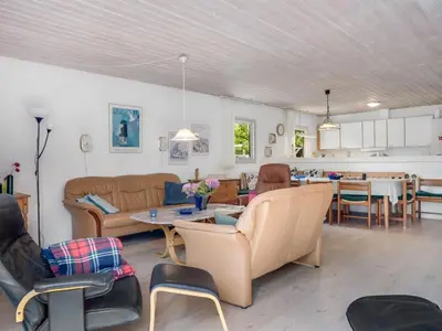 a living room with couches and a dining room at Holiday Home Anine - 200m to the fjord by Interhome in Højslev