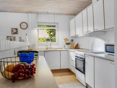 a kitchen with white cabinets and a bowl of fruit on a counter at Holiday Home Anine - 200m to the fjord by Interhome in Højslev