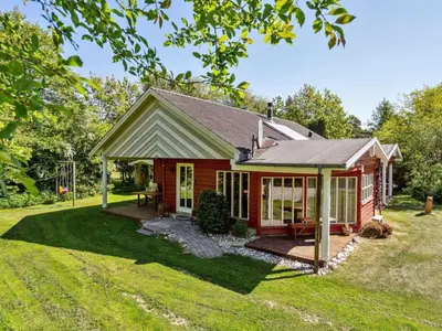 a red house with a porch and a yard at Holiday Home Flugha - 500m to the fjord by Interhome in Thyholm