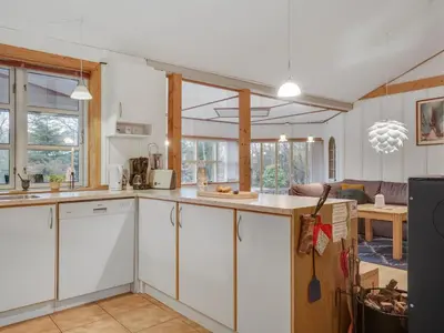 a kitchen with white cabinets and a dining room at Holiday Home Flugha - 500m to the fjord by Interhome in Thyholm