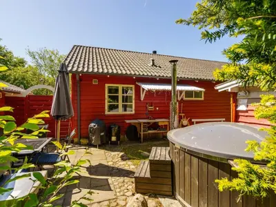 a red house with a hot tub in the yard at Holiday Home Flugha - 500m to the fjord by Interhome in Thyholm