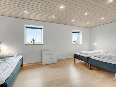two beds in a white room with two windows at Holiday Home Folkar - 3km to the fjord by Interhome in Thyholm