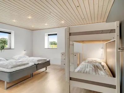 two bunk beds in a bedroom with a wooden ceiling at Holiday Home Folkar - 3km to the fjord by Interhome in Thyholm