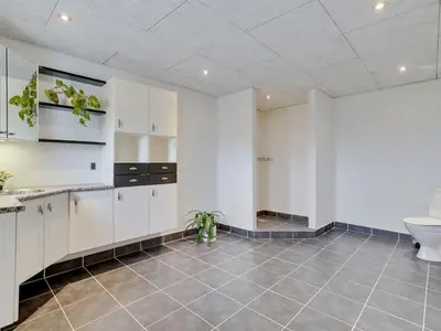 a bathroom with white cabinets and a toilet at Holiday Home Folkar - 3km to the fjord by Interhome in Thyholm