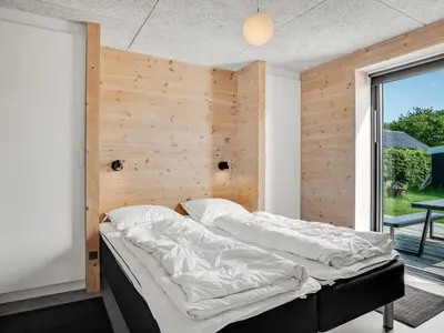 a bedroom with two beds and a wooden wall at Holiday Home Aslag - 150m to the fjord by Interhome in Vinderup