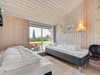 a bedroom with two beds and a large window at Holiday Home Guthmar - 350m to the fjord by Interhome in Vinderup