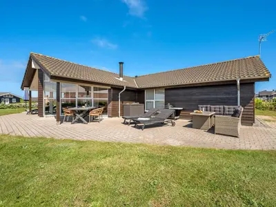 a house with a patio with a table and chairs at Holiday Home Guthmar - 350m to the fjord by Interhome in Vinderup