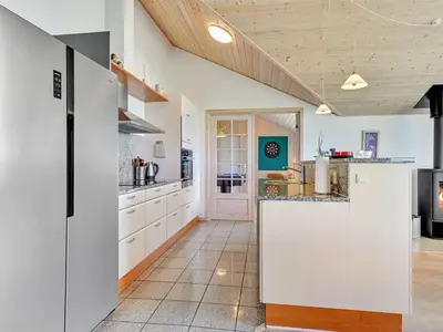 a kitchen with white cabinets and a large island at Holiday Home Guthmar - 350m to the fjord by Interhome in Vinderup
