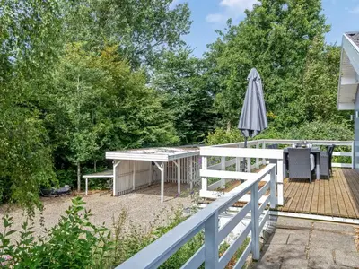 a deck with a table and an umbrella at Holiday Home Gudfast - 300m to the fjord by Interhome in Thyholm