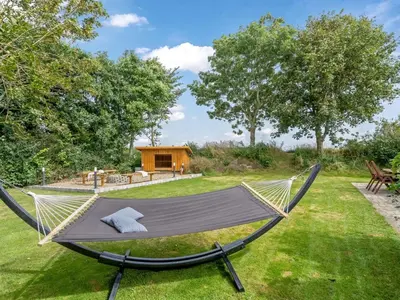 a hammock in a yard with a house in the background at Holiday Home Gudfast - 300m to the fjord by Interhome in Thyholm