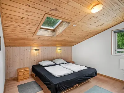 a bed in a room with a wooden ceiling at Holiday Home Gudfast - 300m to the fjord by Interhome in Thyholm