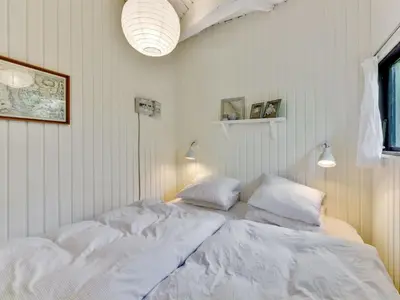 a bedroom with two beds with white sheets at Holiday Home Alika - 200m to the fjord by Interhome in Thyholm