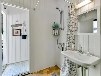 a bathroom with a sink and a shower at Holiday Home Alika - 200m to the fjord by Interhome in Thyholm