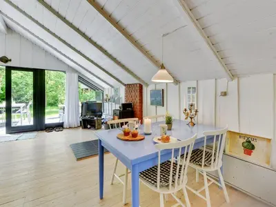 a dining room with a blue table and chairs at Holiday Home Alika - 200m to the fjord by Interhome in Thyholm