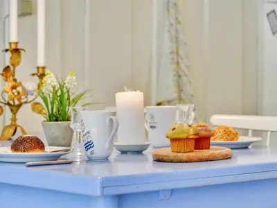 a blue table with a candle and cupcakes on it at Holiday Home Alika - 200m to the fjord by Interhome in Thyholm