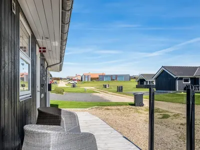 a porch with a chair on the side of a house at Holiday Home Ginia - 150m to the fjord by Interhome in Vinderup