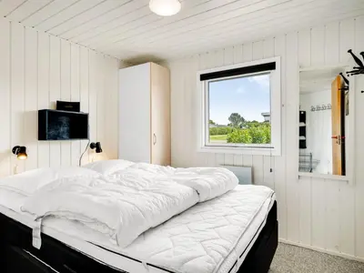 a large bed in a room with a window at Holiday Home Titta - 150m to the fjord by Interhome in Vinderup