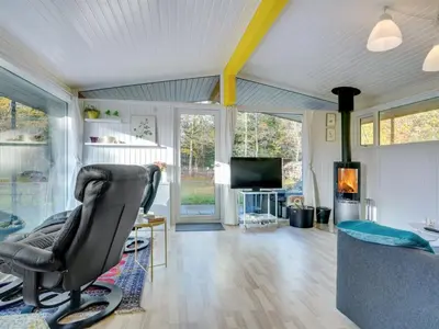a living room with a chair and a television at Holiday Home Calli - 400m to the fjord by Interhome in Højslev