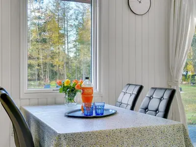 a table with a bottle of orange soda and two glasses at Holiday Home Calli - 400m to the fjord by Interhome in Højslev
