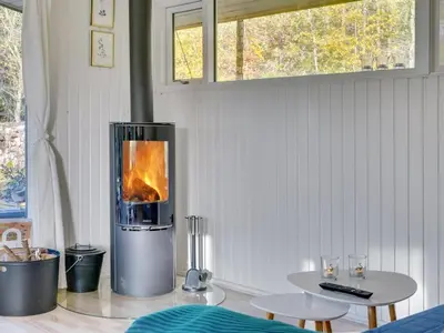 a fireplace in a room with a table and chairs at Holiday Home Calli - 400m to the fjord by Interhome in Højslev