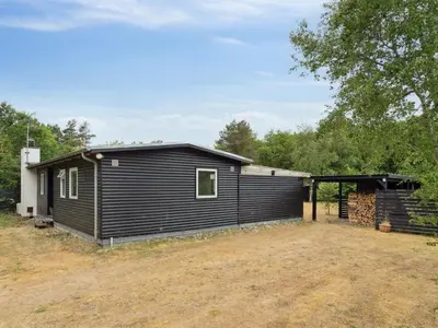 a black house with a garage at Holiday Home Akke - 150m to the fjord by Interhome in Spottrup