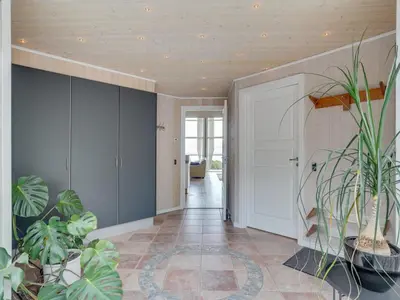 a hallway with potted plants and a white door at Holiday Home Regnwald - 400m to the fjord by Interhome in Spottrup