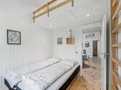 a large bed in a room with white walls at Holiday Home Veijo - 400m to the fjord by Interhome in Spottrup