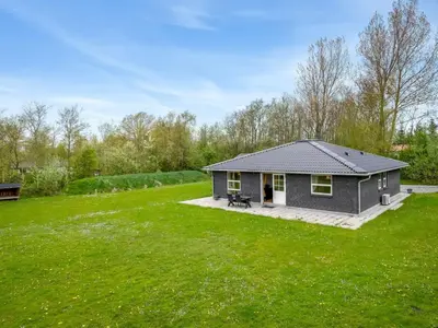 a small house in a yard with a green lawn at Holiday Home Veijo - 400m to the fjord by Interhome in Spottrup