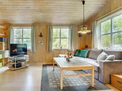 a living room with a couch and a table at Holiday Home Blome - 150m to the fjord by Interhome in Højslev