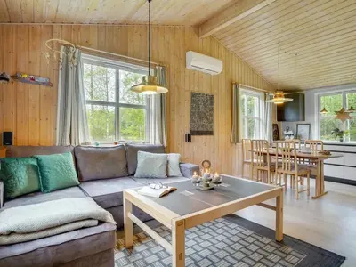 a living room with a couch and a table at Holiday Home Blome - 150m to the fjord by Interhome in Højslev