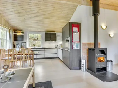 a kitchen and dining room with a wood stove at Holiday Home Blome - 150m to the fjord by Interhome in Højslev