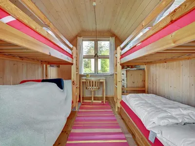 two bunk beds in a small room with a window at Holiday Home Tordis - 250m to the fjord by Interhome in Roslev