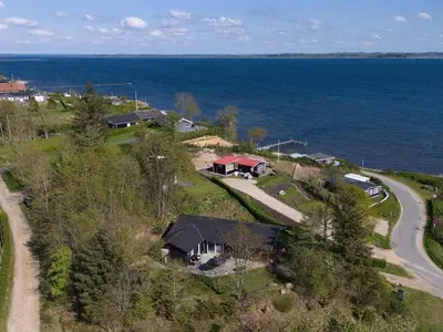 an aerial view of a house by the water at Holiday Home Elissa - 50m to the fjord by Interhome in Roslev