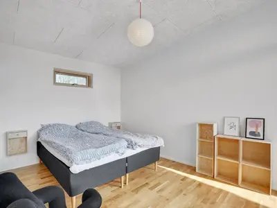 a bedroom with a bed and a chair in it at Holiday Home Haubert - 500m to the fjord by Interhome in Lihme